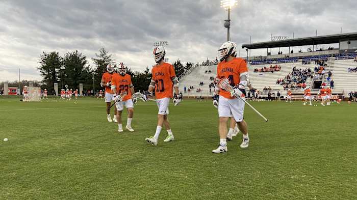 Petey LaSalla, Xander Dickson, and Payton Cormier walk on the field during warm-ups before the Virginia men's lacrosse game against Duke at Klockner Stadium.
